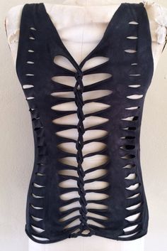 a white mannequin with black leather cutouts on it's back and sides