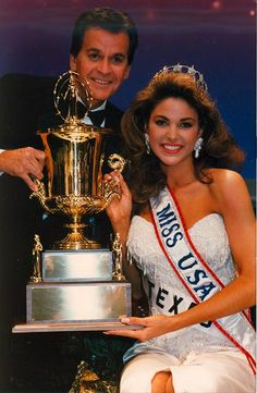 a man and woman posing with a trophy