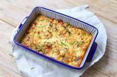 a casserole dish with vegetables and cheese in it on top of a napkin