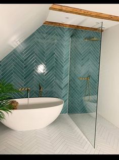 the bathroom is decorated in blue and white tile, with a free standing tub next to it