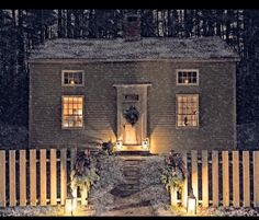 a house is lit up at night with christmas wreaths on the front and side