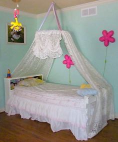 a child's bedroom decorated in pastel blue and pink with flowers on the ceiling