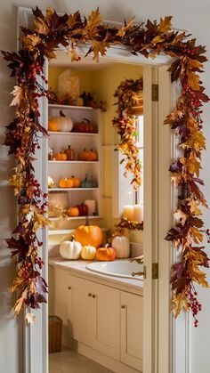 an open door to a kitchen filled with fall leaves