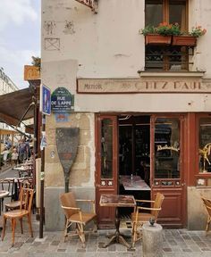 an old building with tables and chairs outside