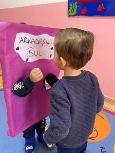 a little boy holding a purple bag with the words aramandusu sul on it