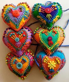 several colorful heart shaped ornaments hanging on a string