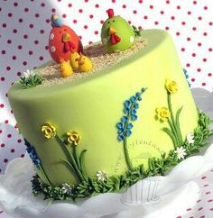 a green cake decorated with birds and flowers