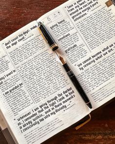 an open bible with a pen resting on it