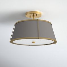 a ceiling light with a gray shade on it's side and a gold frame