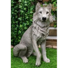 a statue of a wolf sitting in the grass