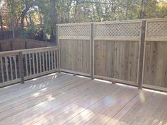 a wooden deck with fence and privacy gate