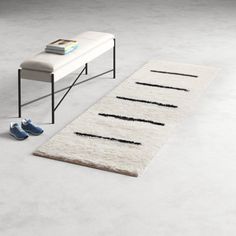 a white rug sitting on top of a floor next to a bench