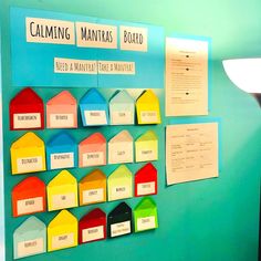 a bulletin board with many different colored houses on it's sides and labels attached to the wall