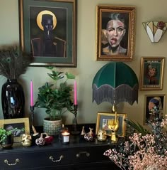 a black dresser topped with pictures and candles