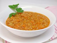 a white bowl filled with soup on top of a plate