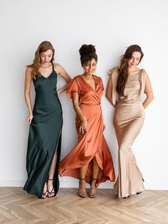 three beautiful women standing next to each other in long dresses and high heeled sandals