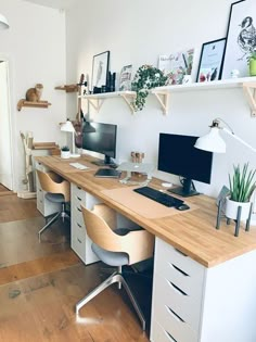 a desk with two computer monitors on top of it and some shelves above the desk