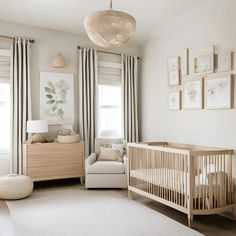 a baby's room with a crib, rocking chair and pictures on the wall