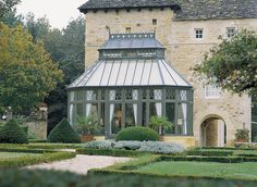 a large building with many windows and bushes in front of it