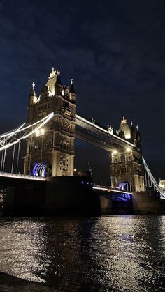 the tower bridge is lit up at night