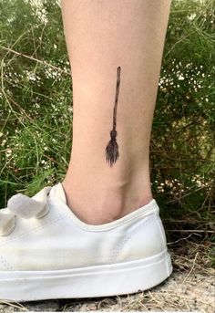 a woman's foot with a small arrow tattoo on the side of her leg