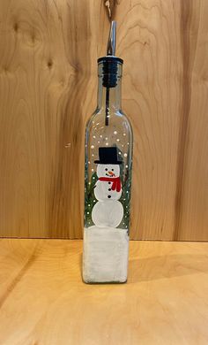 a glass bottle with a snowman painted on it