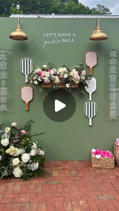 there is a wall with flowers and ping pong paddles hanging on it's side