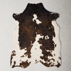 a brown and white cowhide rug on a white background