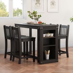 a small table with two chairs next to it and a potted plant on top