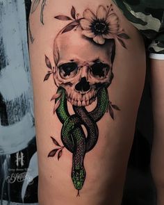 a skull with a snake wrapped around it's neck and flowers on its head