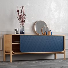 a blue sideboard sitting next to a mirror and vase