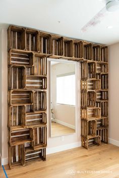 a large wooden book shelf sitting on top of a hard wood floor next to a mirror