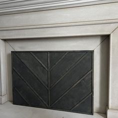 a fire place with a black door on the front and back sides, in a white fireplace mantel