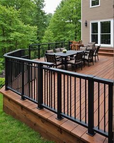 a wooden deck with black railing and chairs