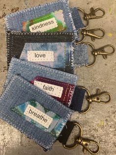 four pairs of jeans with name tags attached to the handles and zippers on them