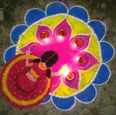 a woman is standing in the middle of a colorful flower design with candles on it