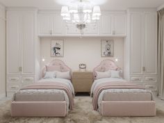 two pink beds in a white bedroom with chandelier