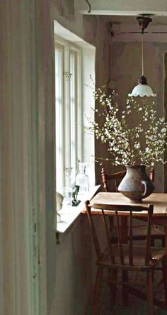 a table and chairs in a room with light coming through the window