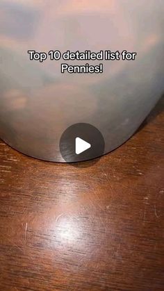 the top ten detailed list for pennies is displayed on a wooden table with a video player