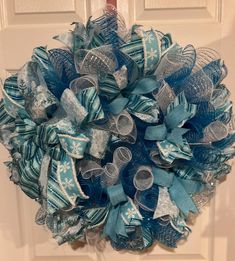 a blue and silver wreath hanging on the front door