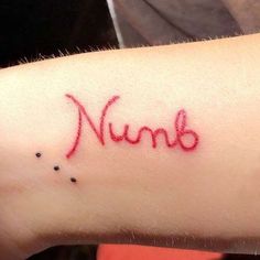 a woman's arm with the word nums written in red ink on it