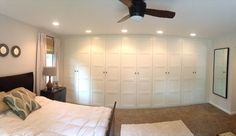 a bedroom with white closets and carpeted flooring in front of the bed