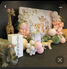 an elephant, giraffe and balloon decorations are on display at a children's birthday party