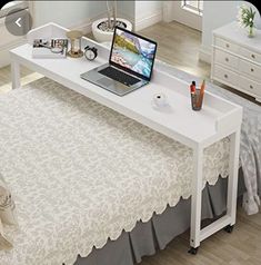 a bedroom with a bed, desk and laptop computer on it's side table