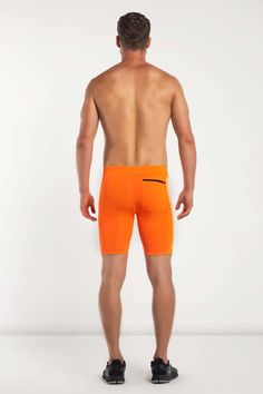 a man in an orange boxer shorts with his back to the camera, looking down