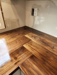 an unfinished kitchen counter top with white cabinets and wood flooring in the background, under construction