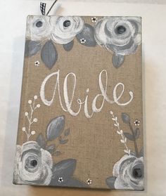 a wooden sign with flowers and the word bride painted on it's front side