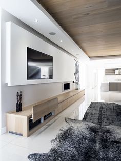 a living room filled with furniture and a flat screen tv mounted to the side of a wall