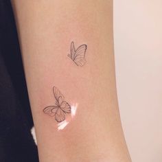 two small butterflies on the wrist and one large butterfly on the other side, both in black ink