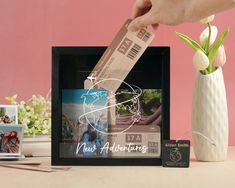 a person holding a card in front of a photo frame